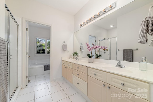 bathroom featuring double vanity, a stall shower, a sink, tile patterned flooring, and a bath