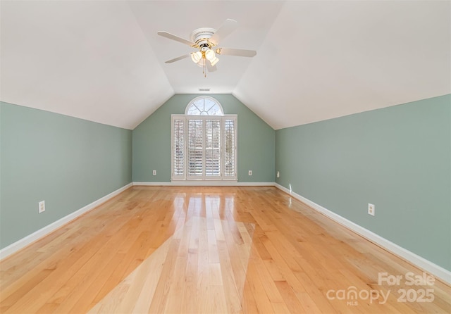 additional living space with visible vents, baseboards, a ceiling fan, lofted ceiling, and wood-type flooring