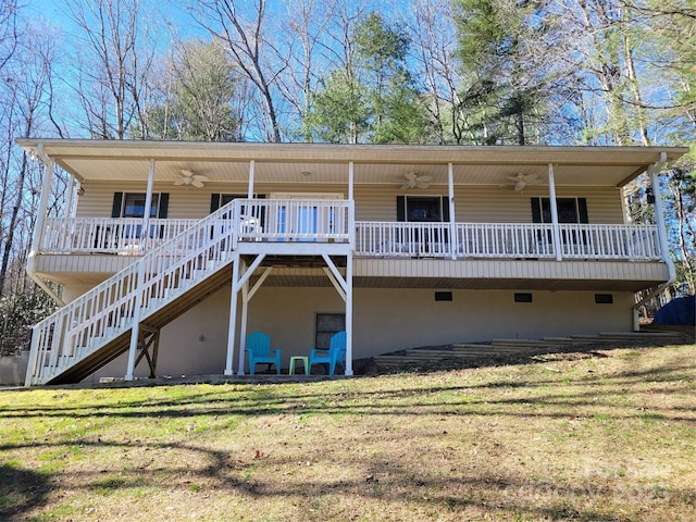 rear view of house with ceiling fan, stairs, a lawn, and a wooden deck