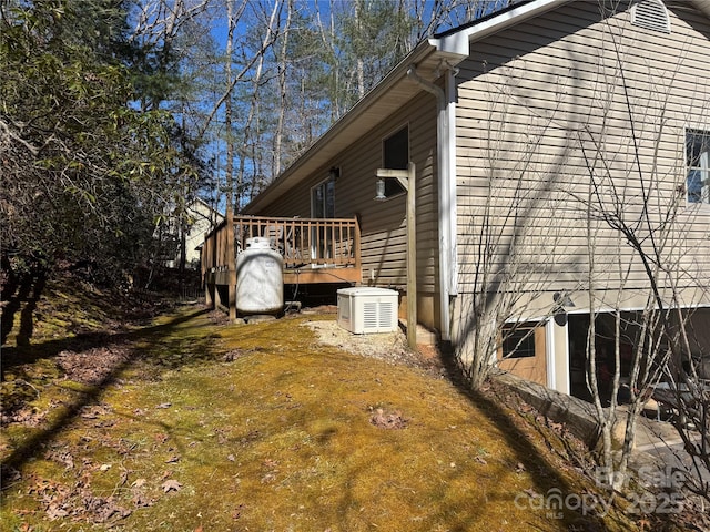 view of side of property with a deck and a lawn