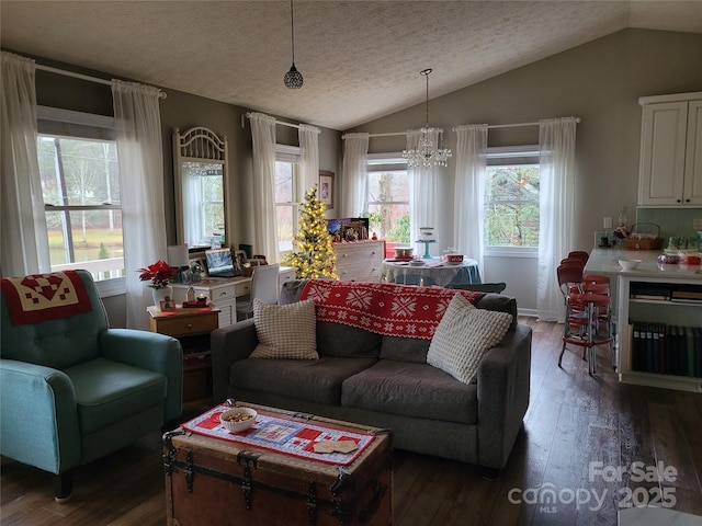 living room with lofted ceiling, a textured ceiling, an inviting chandelier, and hardwood / wood-style flooring