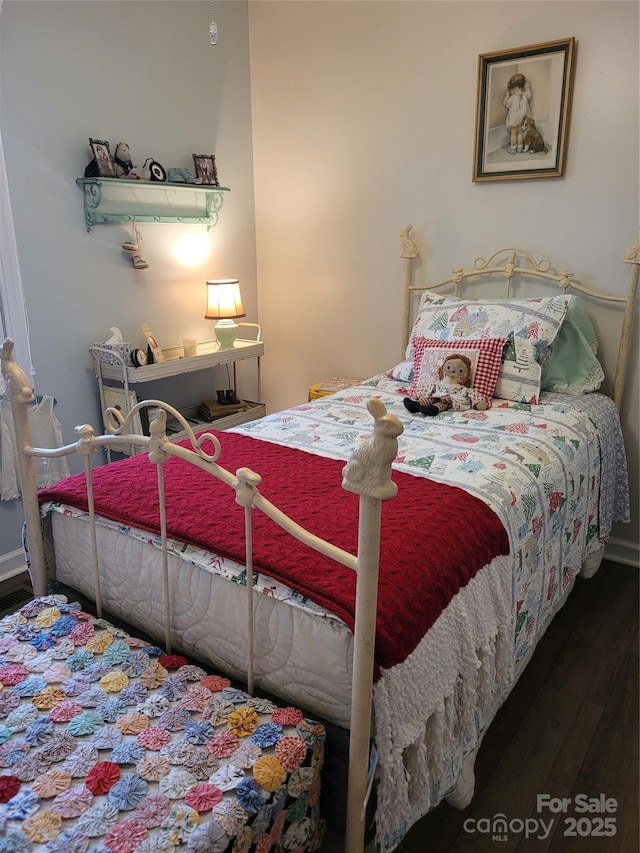 bedroom with wood finished floors and baseboards