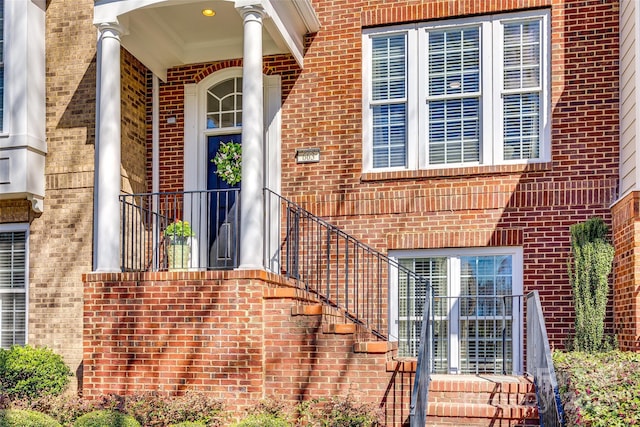 view of exterior entry featuring brick siding