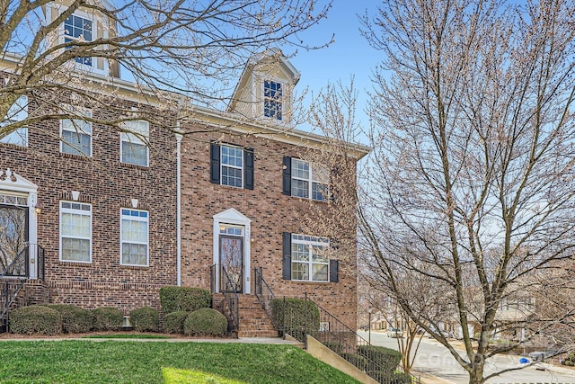 view of front of home with a front yard and brick siding