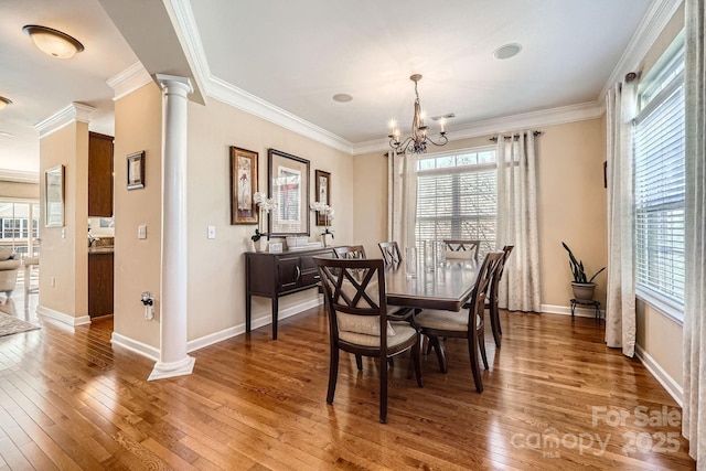 dining area featuring crown molding, wood-type flooring, and ornate columns