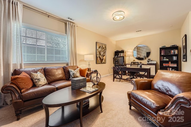 living room featuring baseboards, visible vents, and light colored carpet