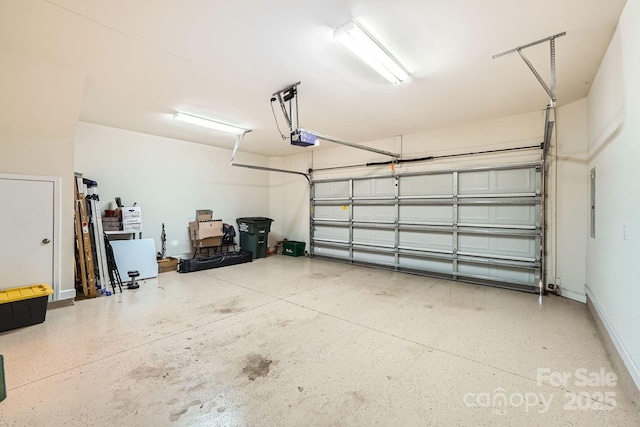 garage featuring a garage door opener and baseboards