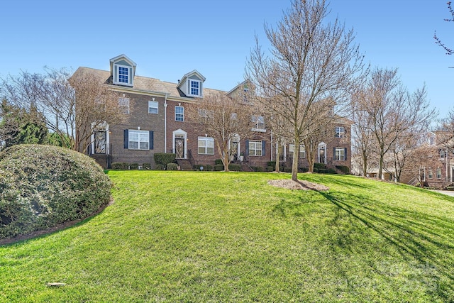 georgian-style home featuring brick siding and a front yard