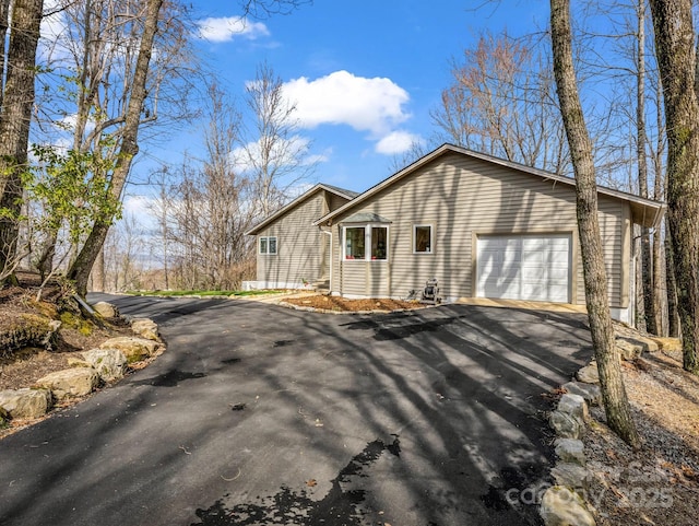 view of property exterior with aphalt driveway and an attached garage