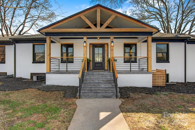 view of front of property featuring brick siding and a porch