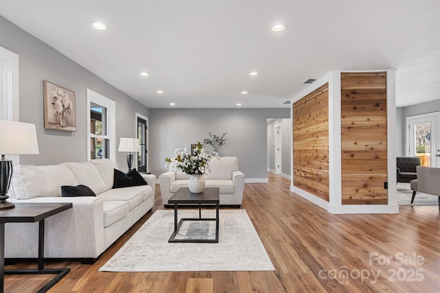 living area featuring recessed lighting, visible vents, baseboards, and light wood-style floors