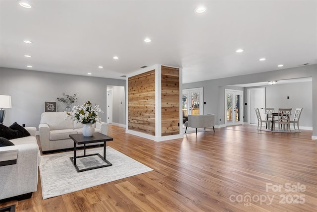 living area featuring recessed lighting, baseboards, and light wood-style flooring