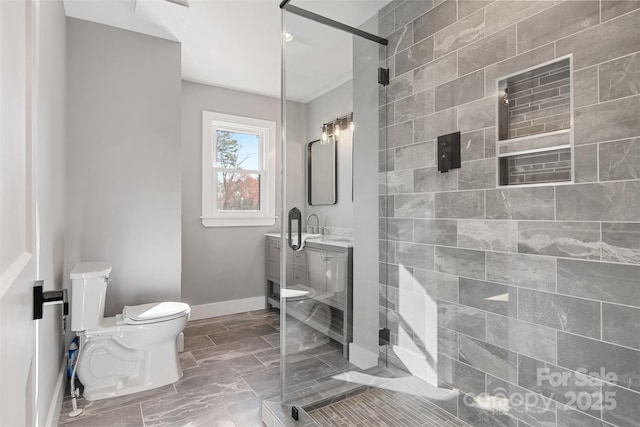 full bath with baseboards, vanity, toilet, and a shower stall