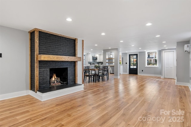 unfurnished living room with recessed lighting, a fireplace, and light wood-style floors