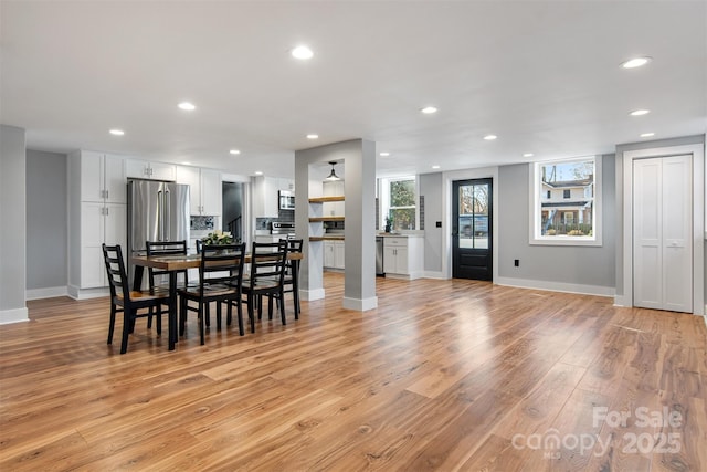 dining room with light wood-style flooring, recessed lighting, and baseboards