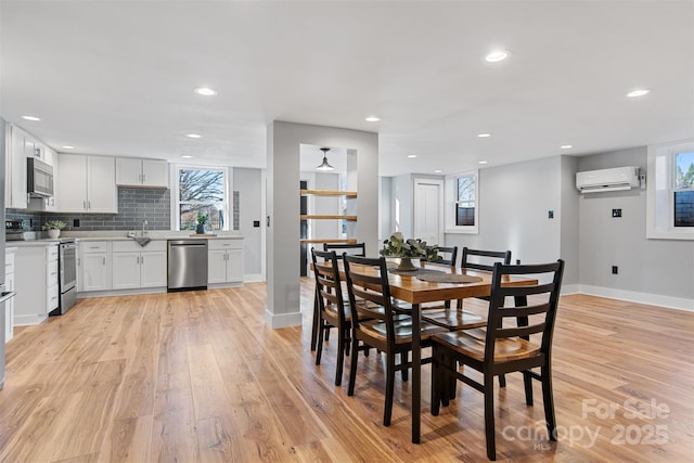 dining space with light wood-style flooring, recessed lighting, baseboards, and a wall mounted air conditioner