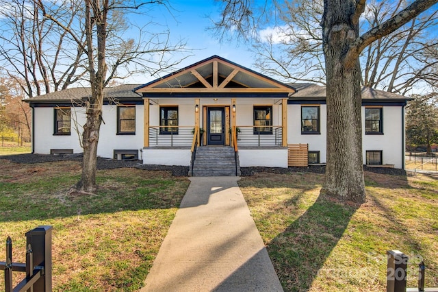 bungalow-style home with brick siding, a porch, and a front lawn