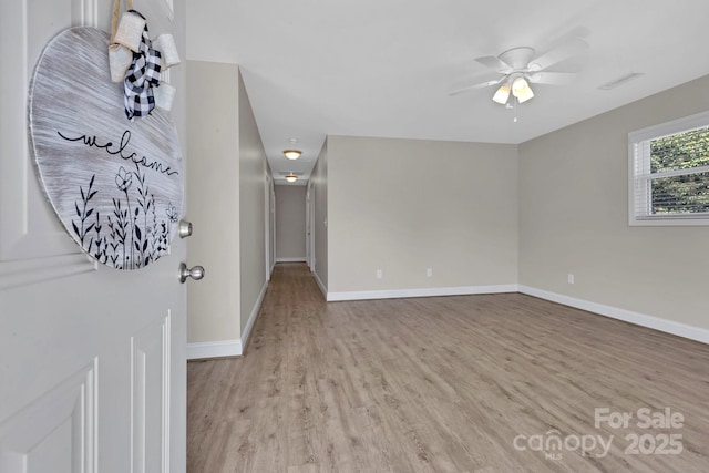 unfurnished living room featuring visible vents, baseboards, wood finished floors, and a ceiling fan