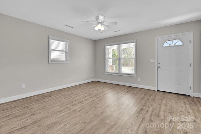 foyer entrance featuring visible vents, baseboards, light wood-style floors, and a ceiling fan