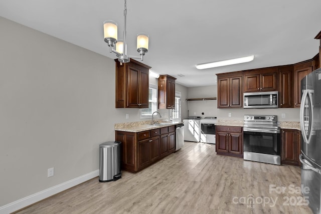 kitchen with stainless steel appliances, light wood-type flooring, baseboards, and a sink