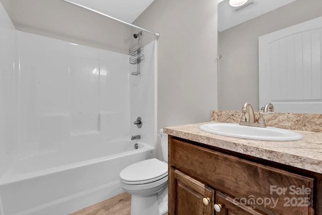 bathroom with visible vents, toilet, bathtub / shower combination, wood finished floors, and vanity