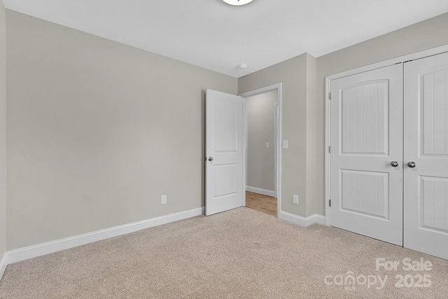 unfurnished bedroom featuring a closet, carpet flooring, and baseboards