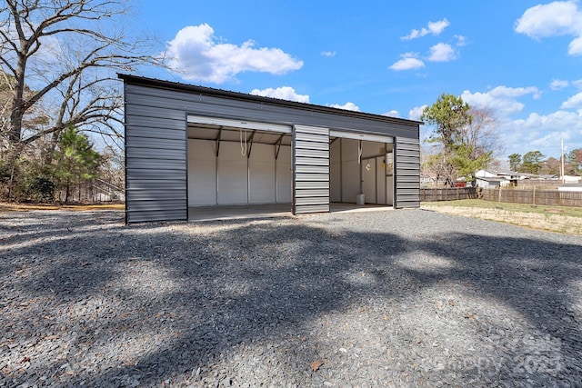 detached garage featuring fence