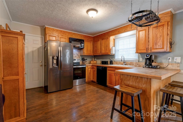 kitchen with tile counters, dark wood finished floors, a breakfast bar area, black appliances, and a sink