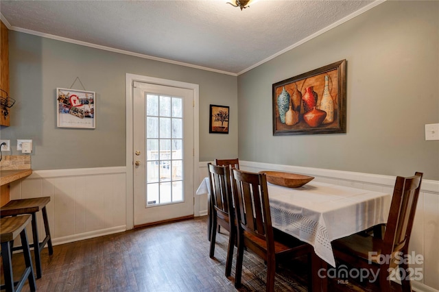 dining area featuring crown molding, wood finished floors, a wainscoted wall, and a textured ceiling