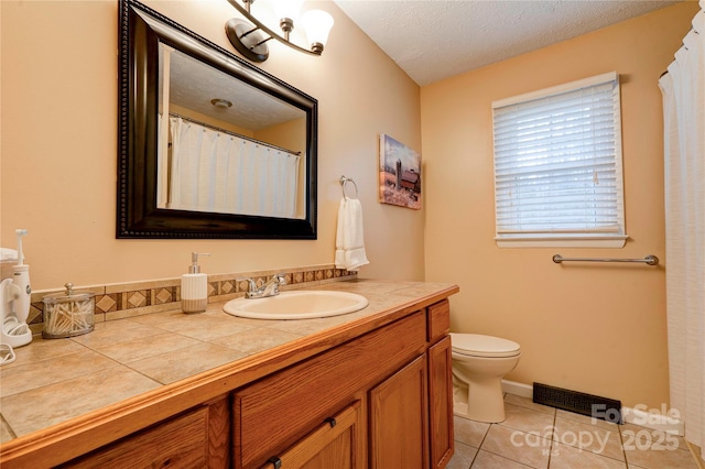 full bathroom featuring tile patterned flooring, visible vents, toilet, vanity, and a textured ceiling