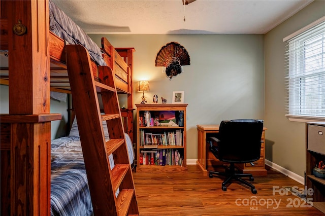 bedroom featuring baseboards and wood finished floors