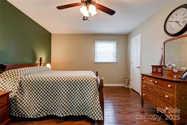 bedroom with baseboards, dark wood-type flooring, ceiling fan, and a textured ceiling