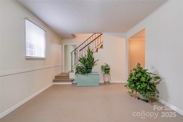 interior space with stairs, baseboards, concrete flooring, and a textured ceiling