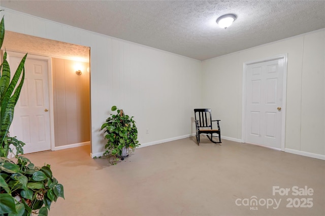 sitting room featuring a textured ceiling and baseboards