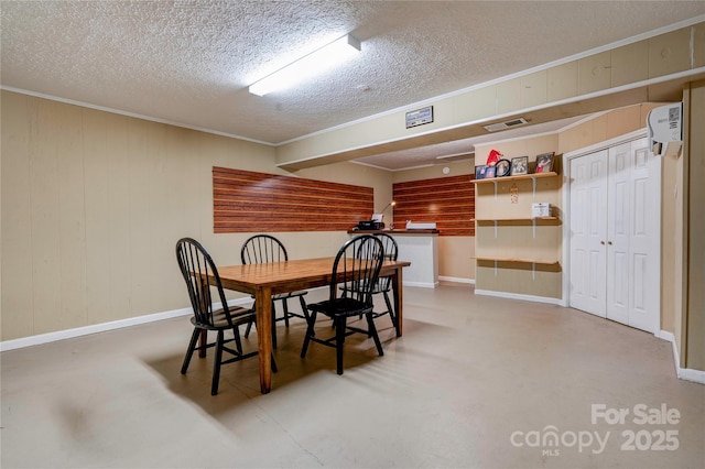 dining area featuring visible vents, a textured ceiling, crown molding, and finished concrete flooring