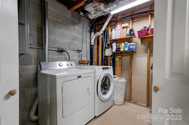 laundry area with concrete block wall, laundry area, and washer and clothes dryer