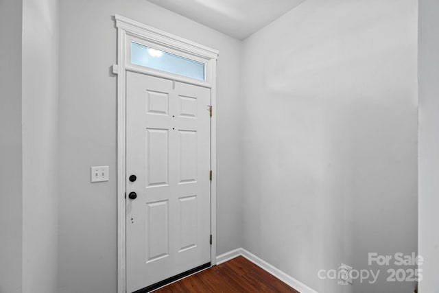 foyer entrance featuring dark wood-style flooring and baseboards