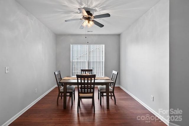 dining room with dark wood-style floors, ceiling fan, and baseboards