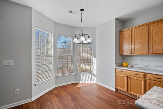 kitchen featuring a chandelier, dark wood-style flooring, visible vents, light countertops, and hanging light fixtures