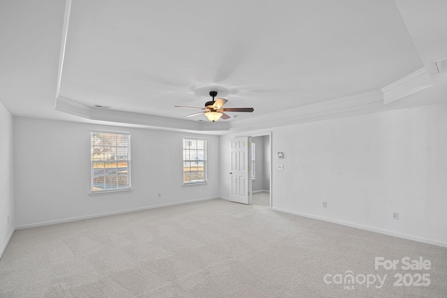 spare room featuring ornamental molding, a tray ceiling, and light colored carpet