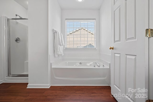 full bath with a garden tub, a shower stall, baseboards, and wood finished floors