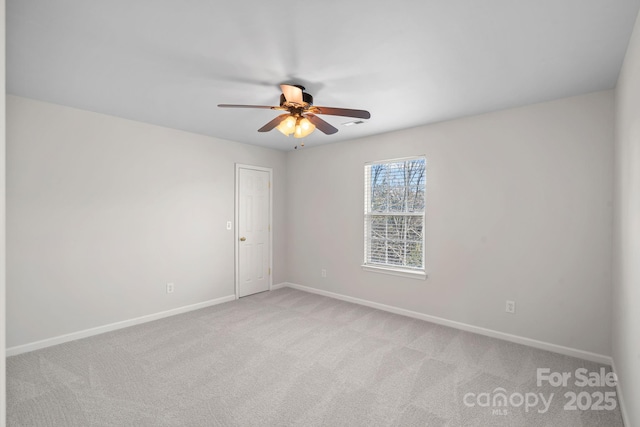 spare room with light carpet, baseboards, and a ceiling fan