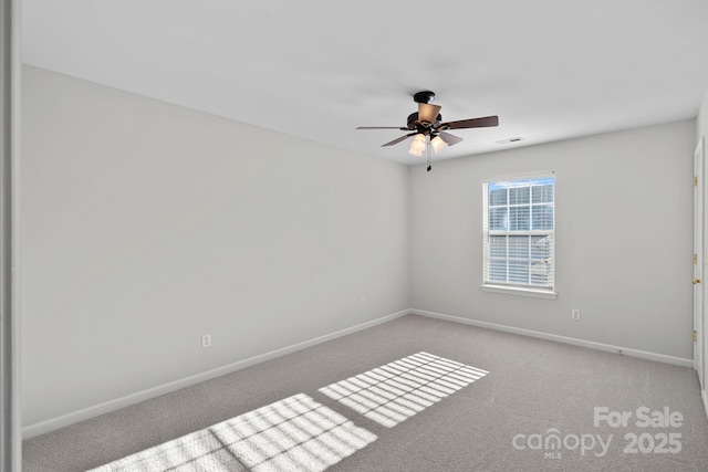 carpeted spare room with a ceiling fan, visible vents, and baseboards