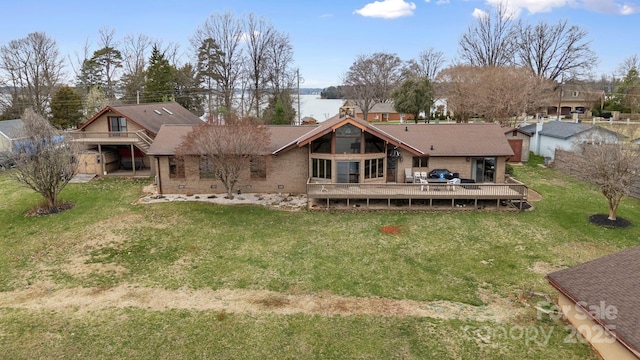 back of property featuring a lawn and a wooden deck