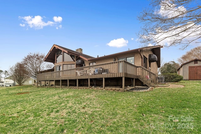 back of house featuring a deck, a shed, a yard, an outdoor structure, and brick siding