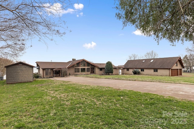 view of front of house with a front lawn, a garage, driveway, and a chimney