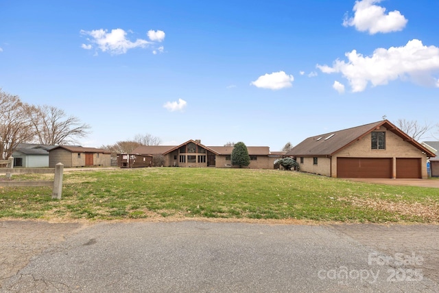 view of front of house with a garage, driveway, and a front yard