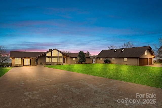 view of front facade featuring a front yard, an attached garage, and driveway