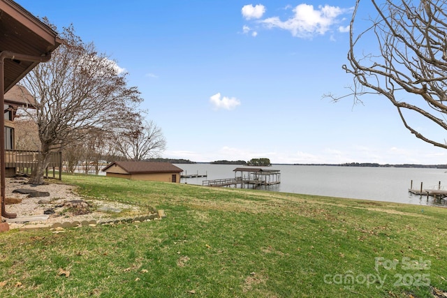 view of yard featuring a water view and a dock