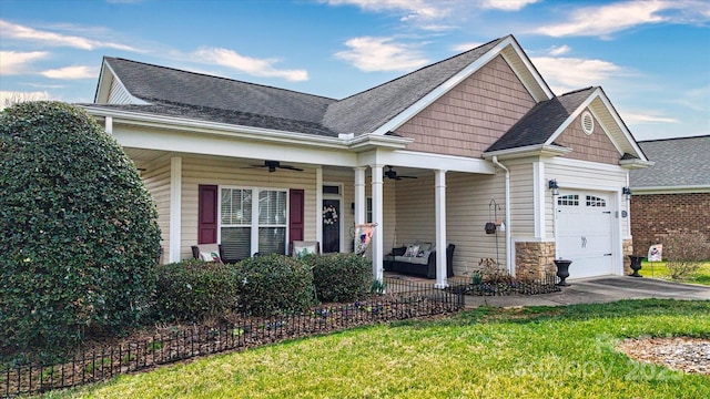 view of front of house featuring a front yard, a porch, ceiling fan, a garage, and stone siding